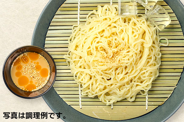 胡麻ざるらーめんの調理イメージ。皿に盛りつけられた麺と、タレの入った器が写っています。